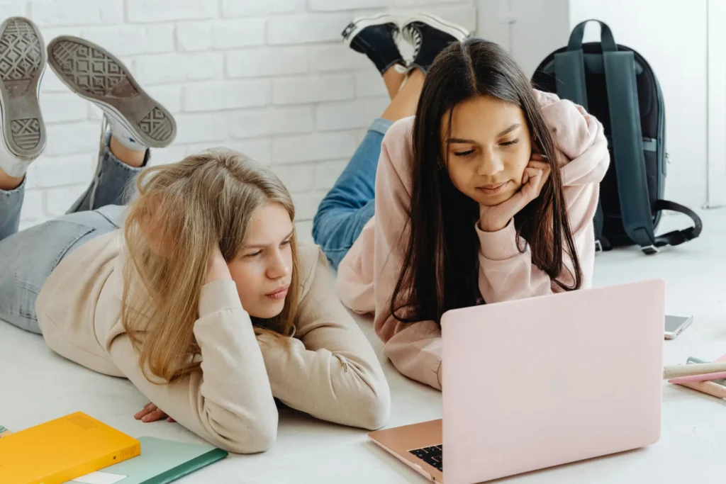 Deux élèves révisent leurs maths ensemble sur un ordinateur portable